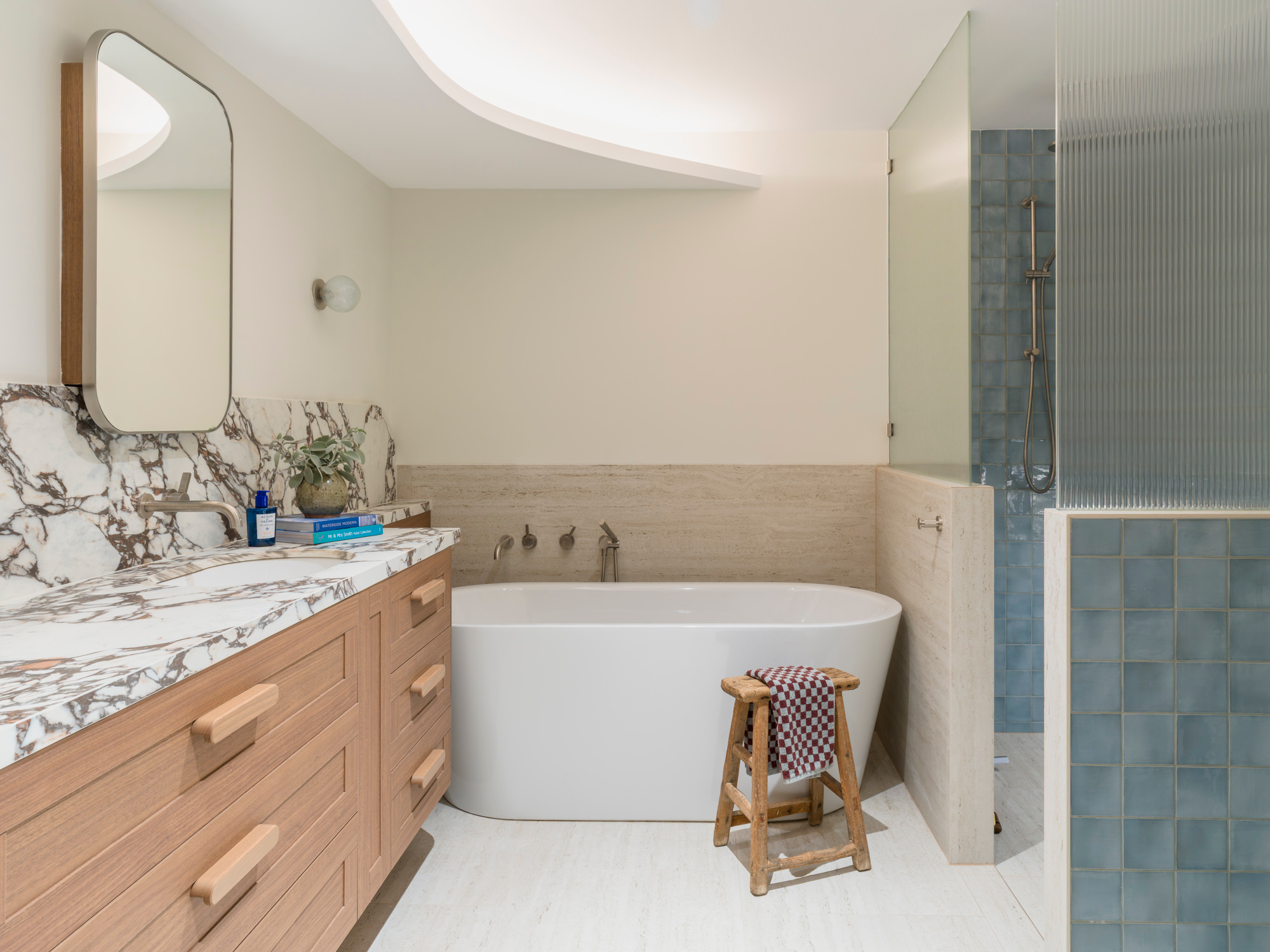 Modern bathroom with marble vanity, freestanding bathtub and shower